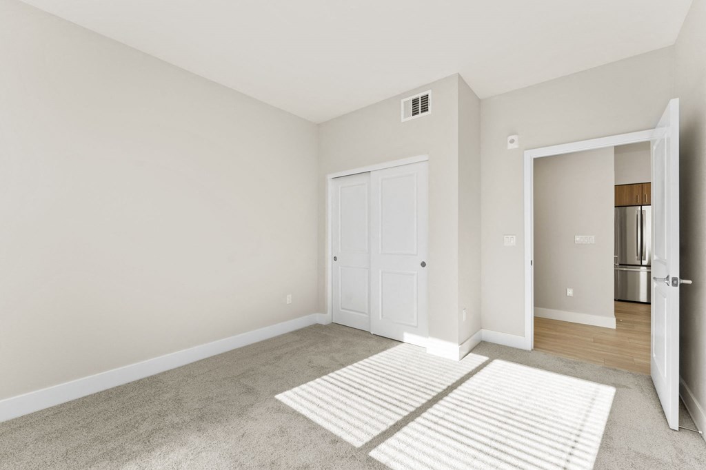 a living room with a rug and a door to a kitchen