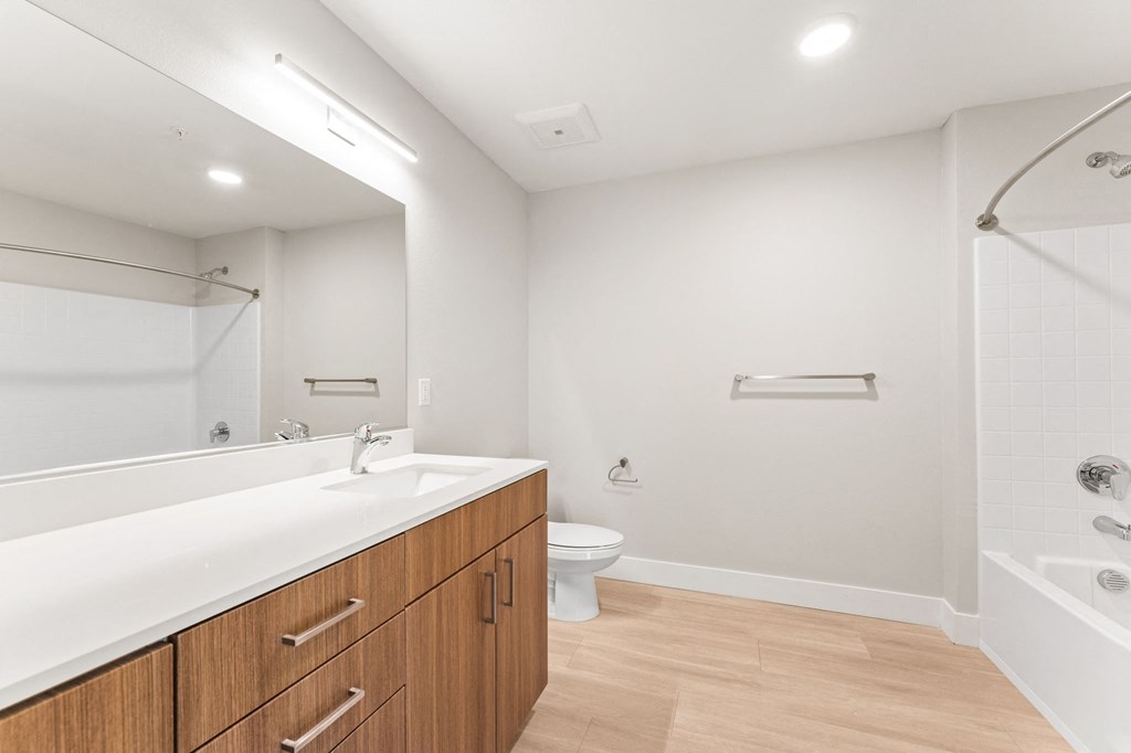 a bathroom with a large mirror and a sink and a toilet