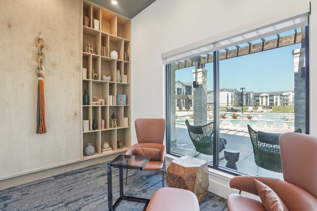 A room with a chair, a table and a window.