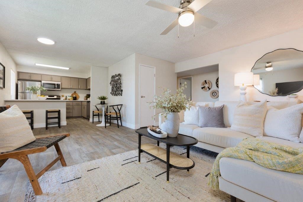 a living room and kitchen with a ceiling fan