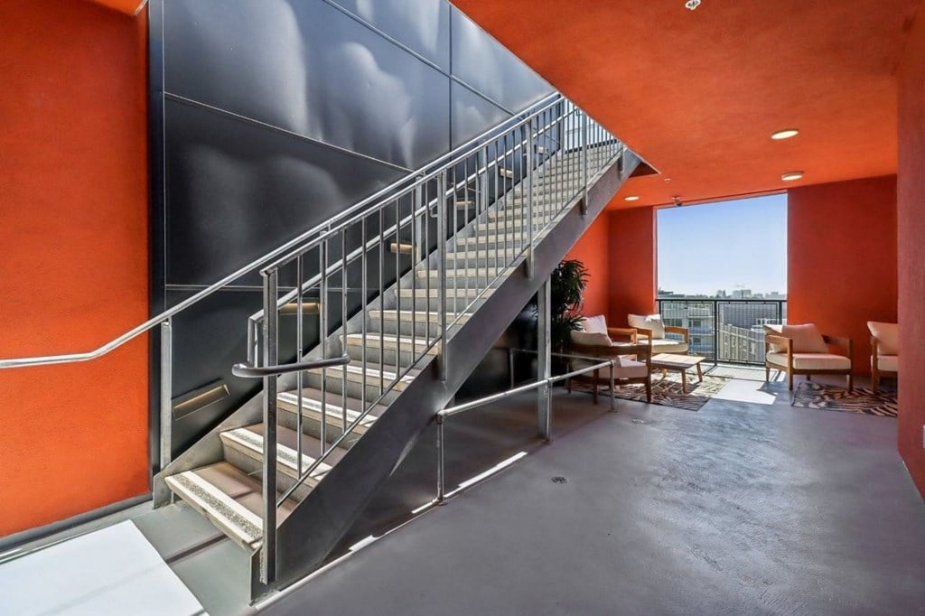 A staircase with a metal railing and steps leading up to a balcony.