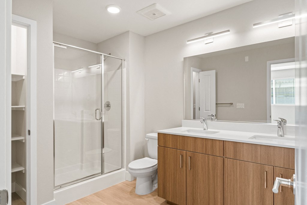 a bathroom with a shower sink and toilet and a mirror