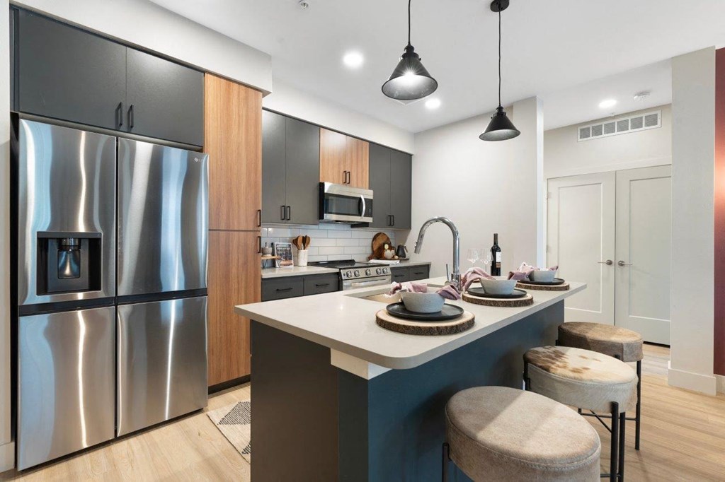 a kitchen with a island and a stainless steel refrigerator