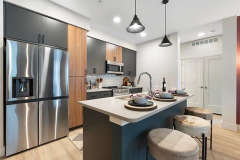 a kitchen with a island and a stainless steel refrigerator
