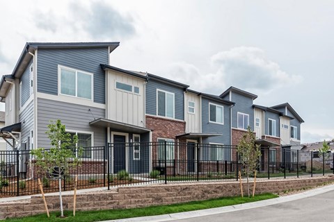 A row of houses with grey and brown exteriors.