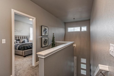 A bedroom with a bed, a mirror, and a small Christmas tree on the counter.