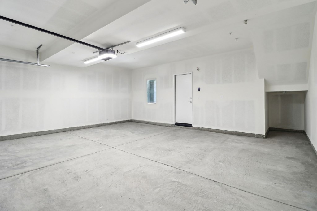 A large empty room with a door and a window.