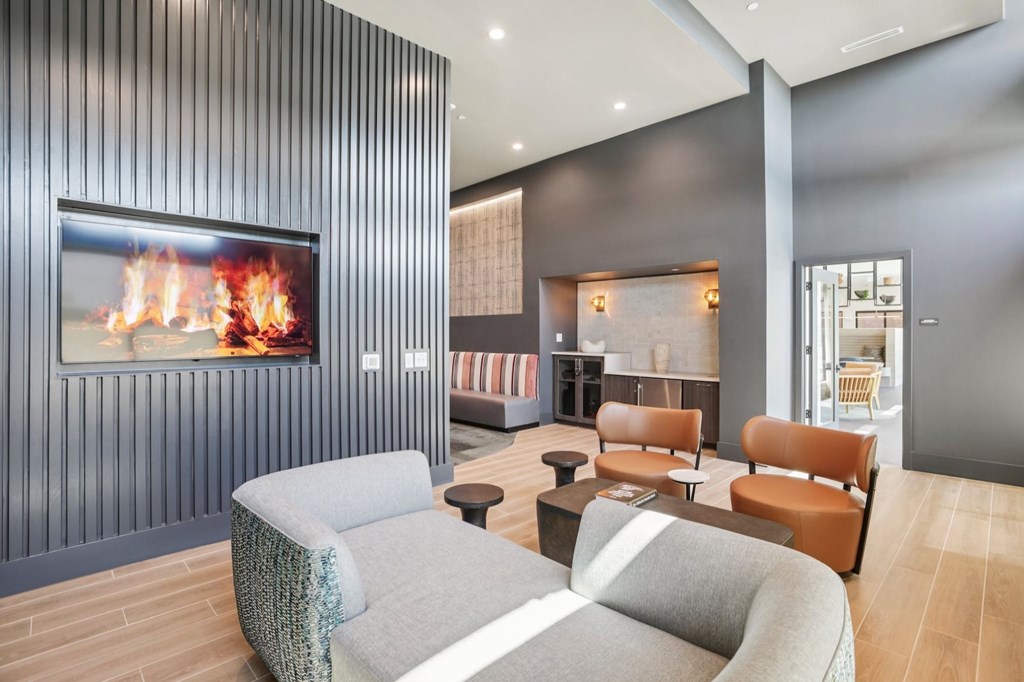 A modern living room with a fireplace and grey couches.