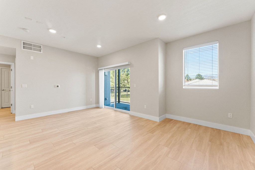 an empty living room with a hard wood floor and a staircase