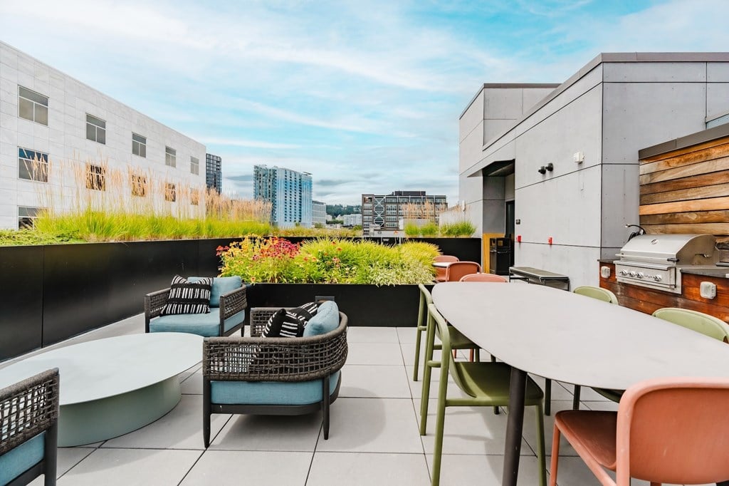 A patio with a table and chairs overlooking a cityscape.