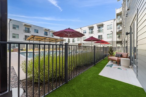 A patio with a pool and a black fence.