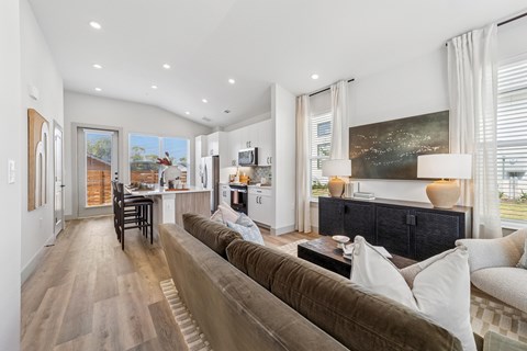 A modern living room with a brown couch and a painting on the wall.