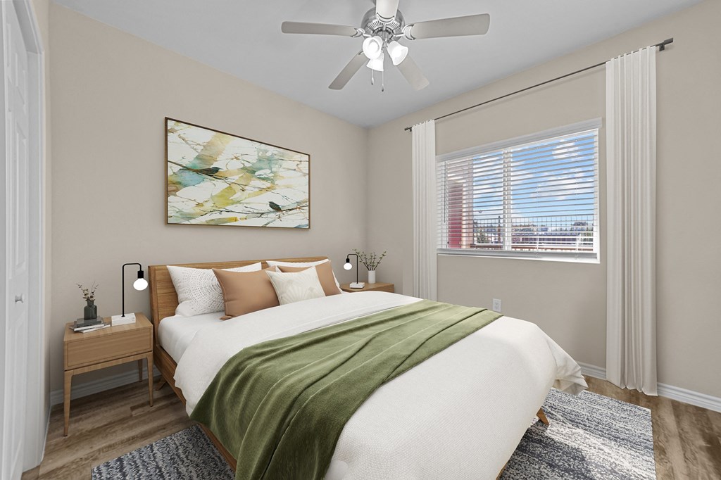 A bedroom with a large bed and a ceiling fan.