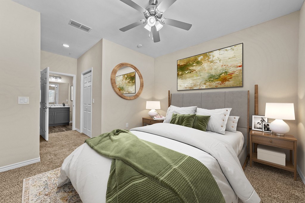A bedroom with a large bed and a ceiling fan.