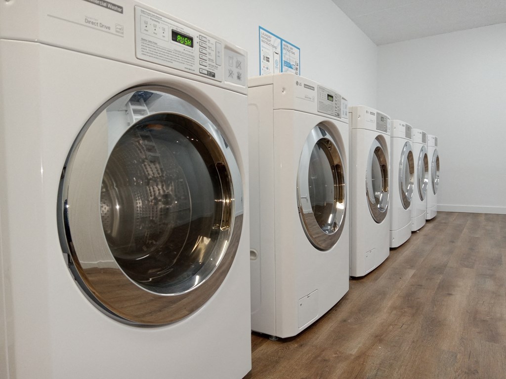 a row of washers and dryers in a laundry room