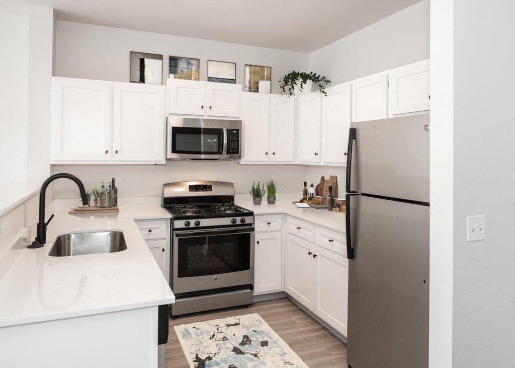 a kitchen with white cabinets and stainless steel appliances