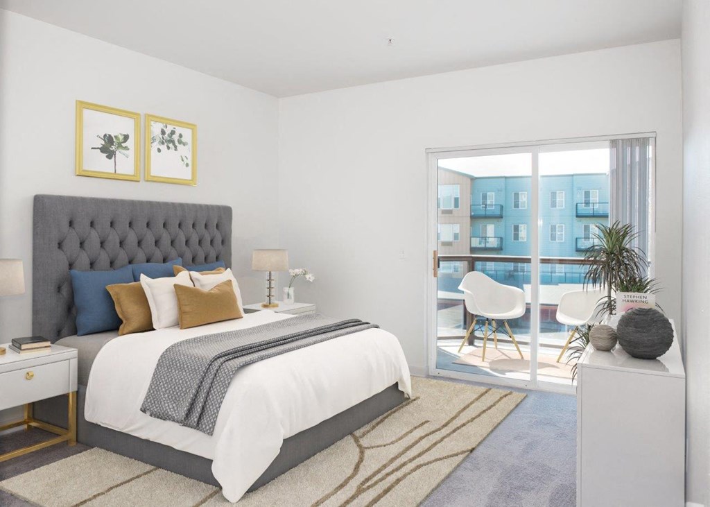 a bedroom with a large bed and a glass door leading to a balcony