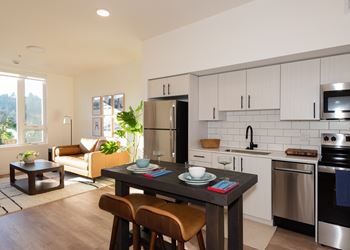 A modern kitchen with a dining table set for two.