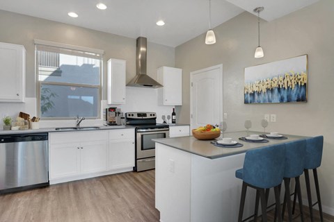 A modern kitchen with white cabinets and a large island.