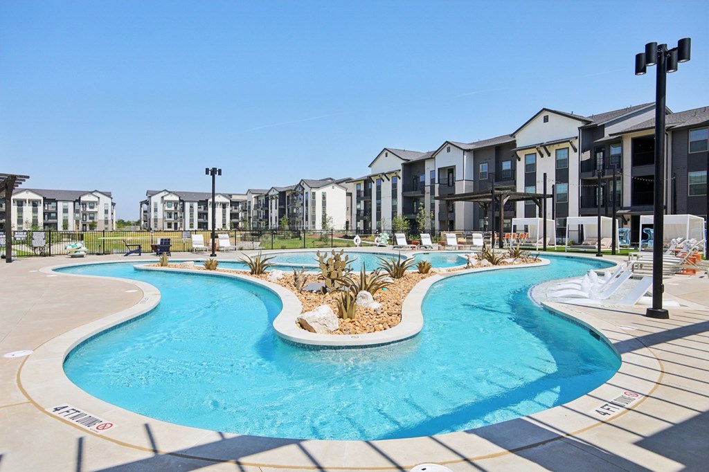A swimming pool in front of a row of houses.