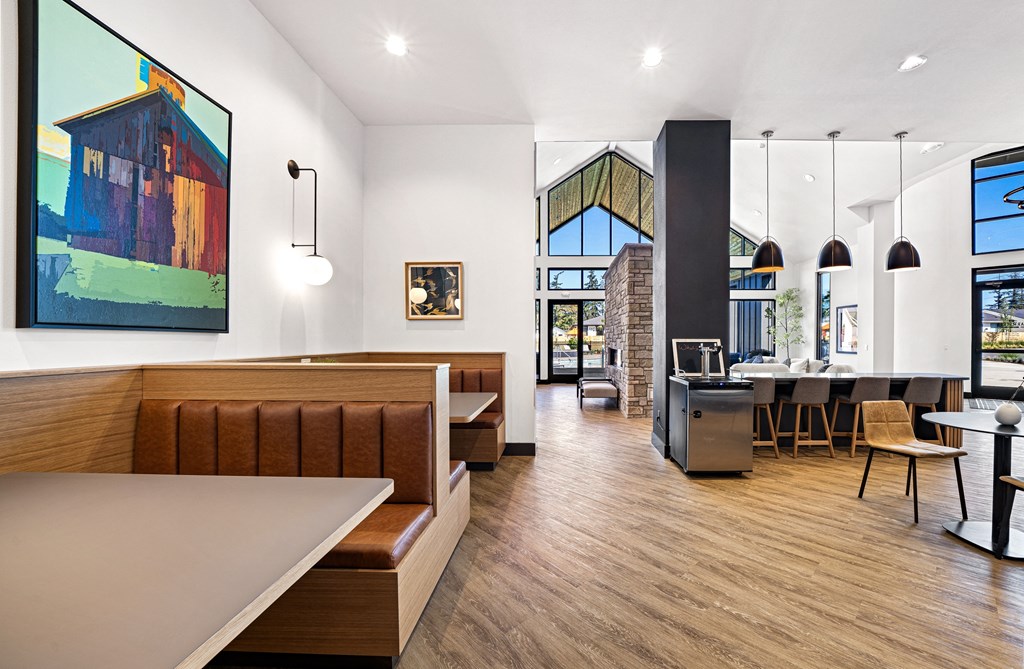 a common room with a kitchen and a dining area with tables and chairs