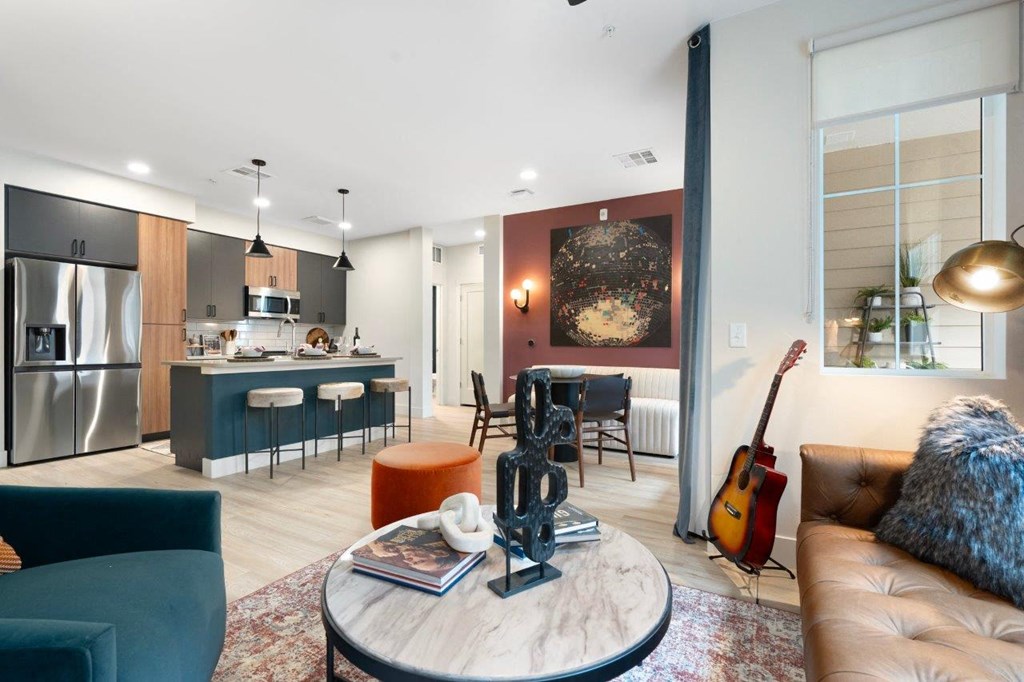 a living room and kitchen with a guitar on the wall