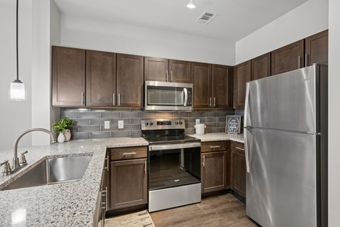 A modern kitchen with a stainless steel refrigerator and wooden cabinets.