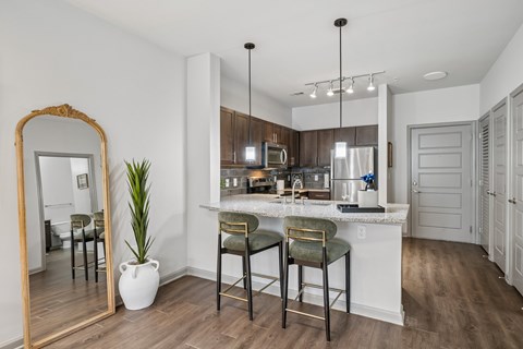 A kitchen with a bar stool and a mirror.