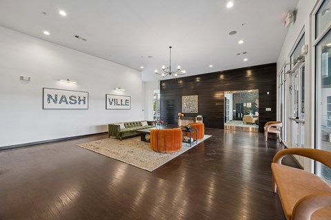 A spacious lobby with a brown floor and a green couch.
