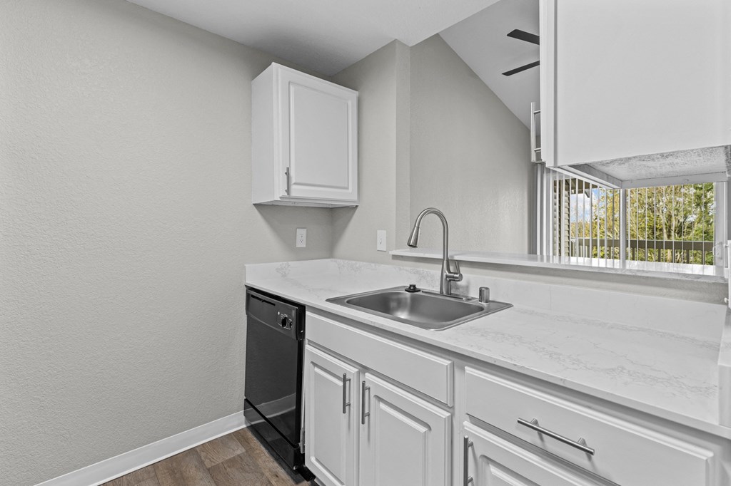 the kitchen of our studio apartment atrium with white cabinets and a sink