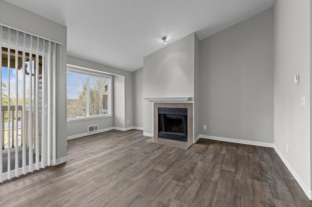 an empty living room with a fireplace and a window