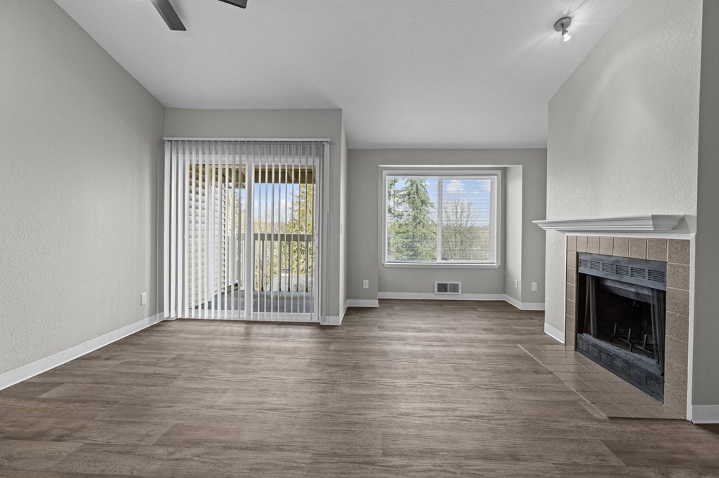 an empty living room with a fireplace and a window