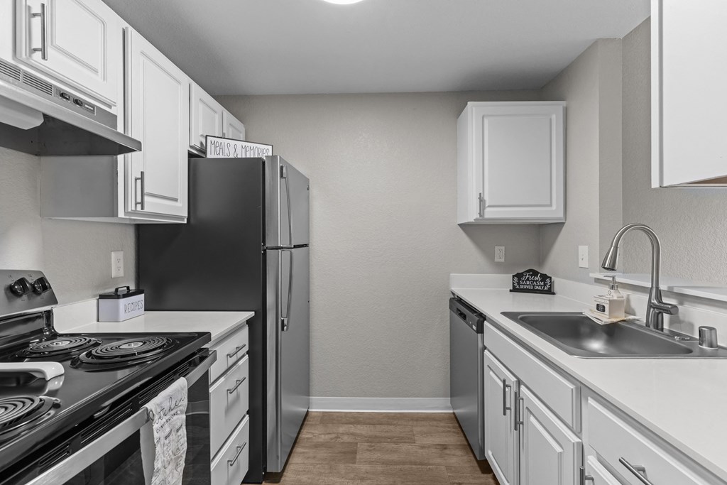 an empty kitchen with white cabinets and stainless steel appliances