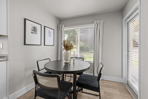 a dining room with a table and chairs and a window