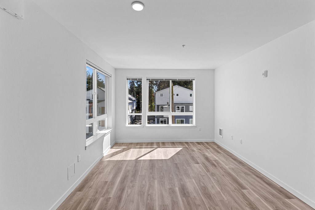 a living room with white walls and a large window