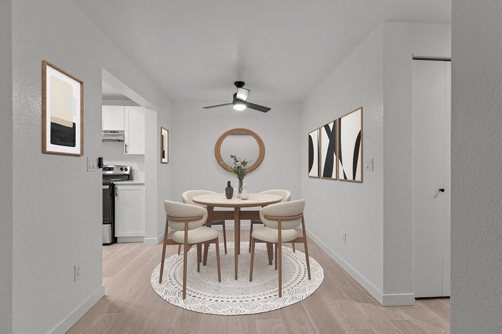 a dining room with a round table and chairs and a ceiling fan