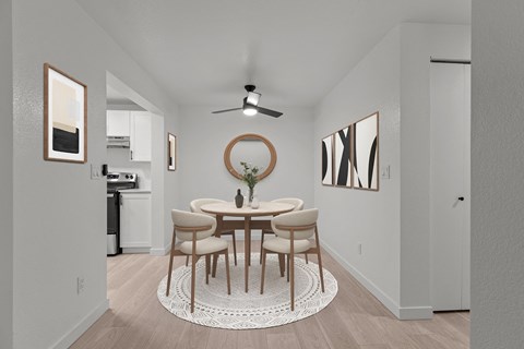 a dining room with a round table and chairs and a ceiling fan
