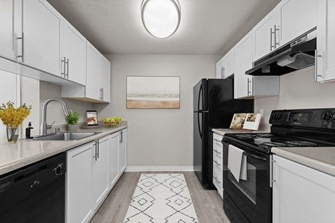 our spacious kitchens are equipped with black appliances and white cabinets
