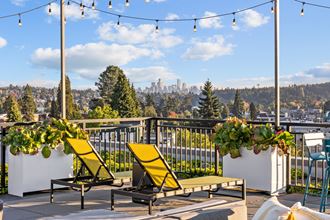 the rooftop deck with lounge chairs and a view of the city