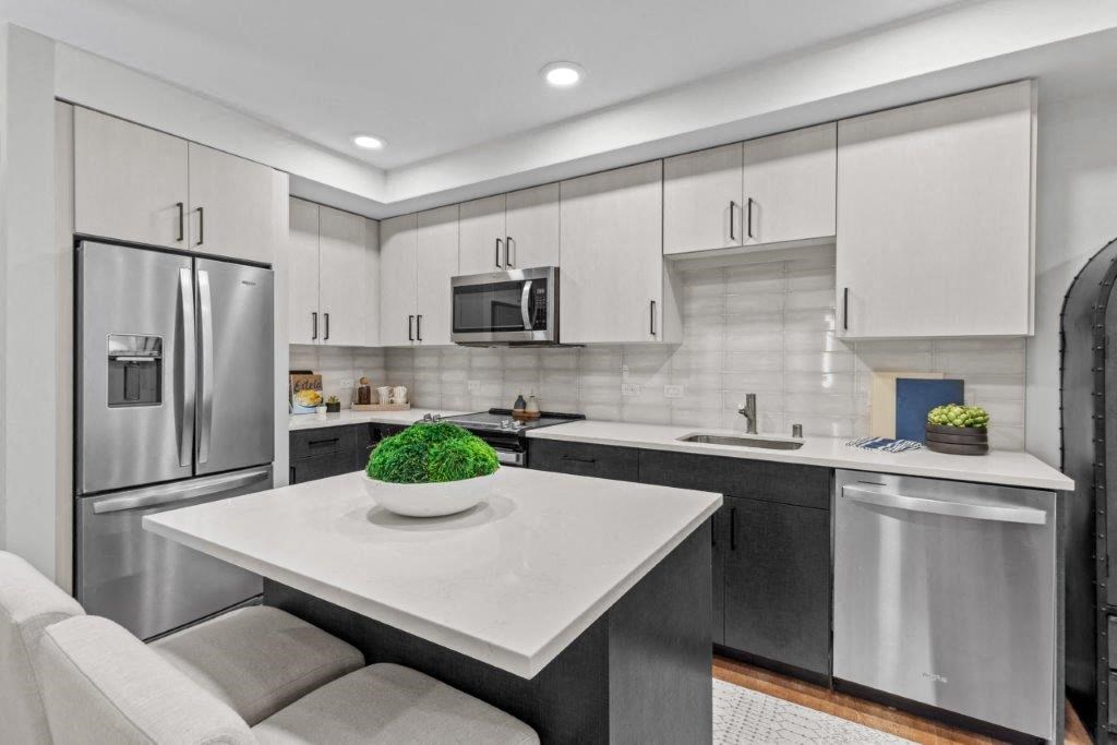 a modern kitchen with stainless steel appliances and a white counter top