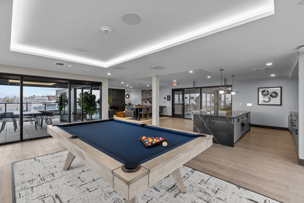 a pool table in a living room with a bar and a television