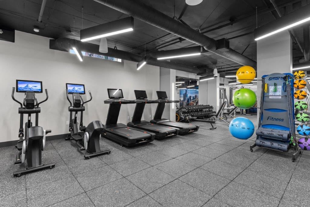 a gym with cardio equipment and weights in a building