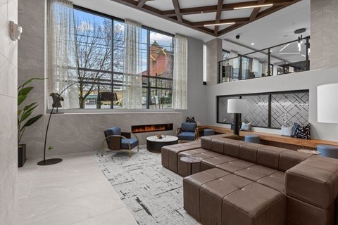 A modern living room with a large window and a fireplace.