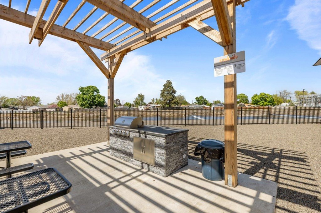 A wooden pergola with a sign that reads