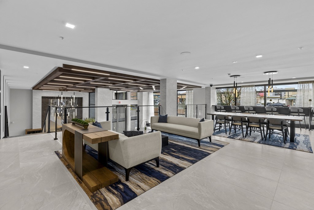 a living room with couches and chairs and a bar with tables and chairs