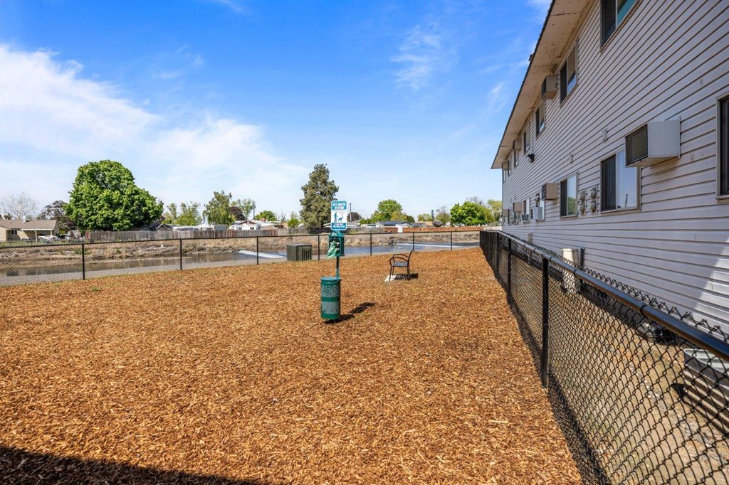 A baseball field with a green sign and a fence.