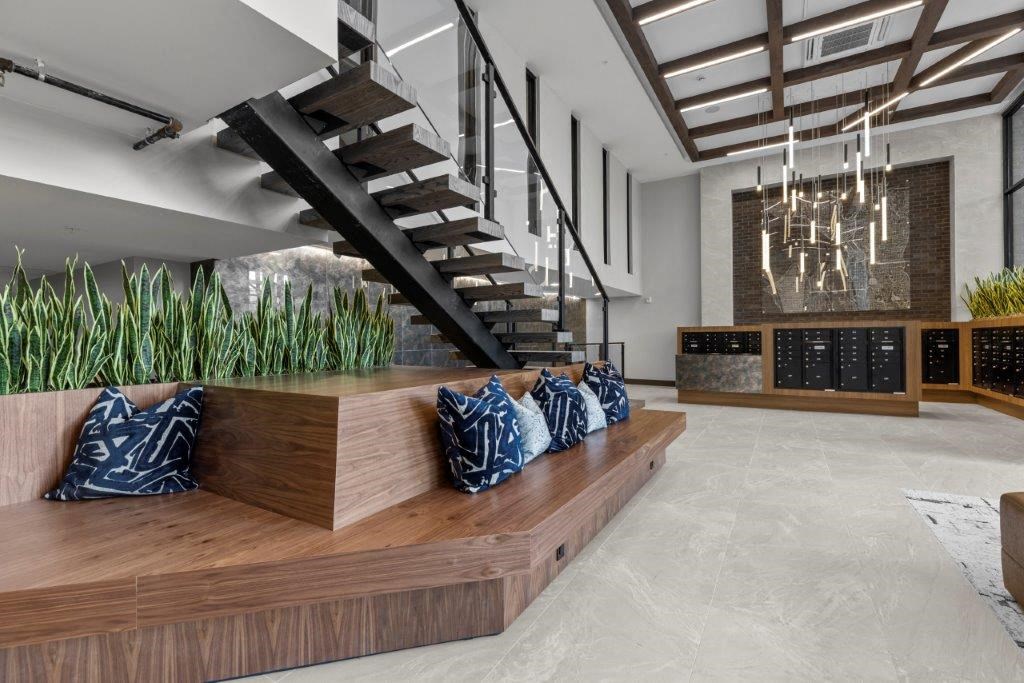 a living room with a wooden bench and a staircase
