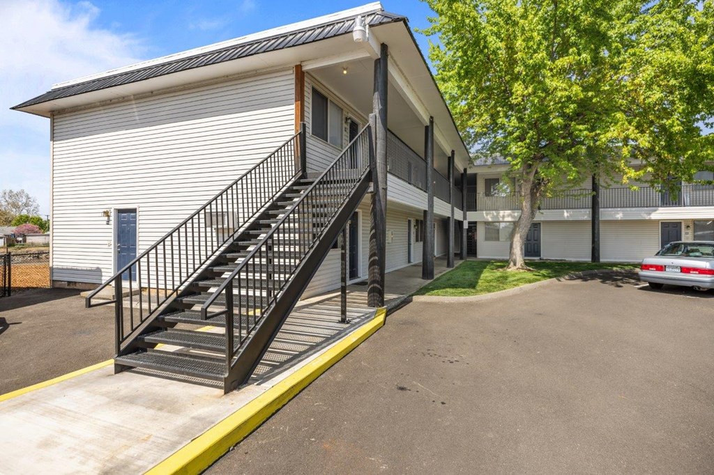 A white building with a black metal staircase.