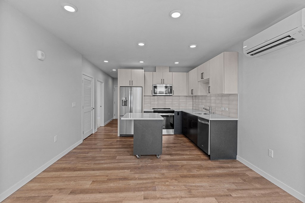 a renovated kitchen with white cabinets and stainless steel appliances