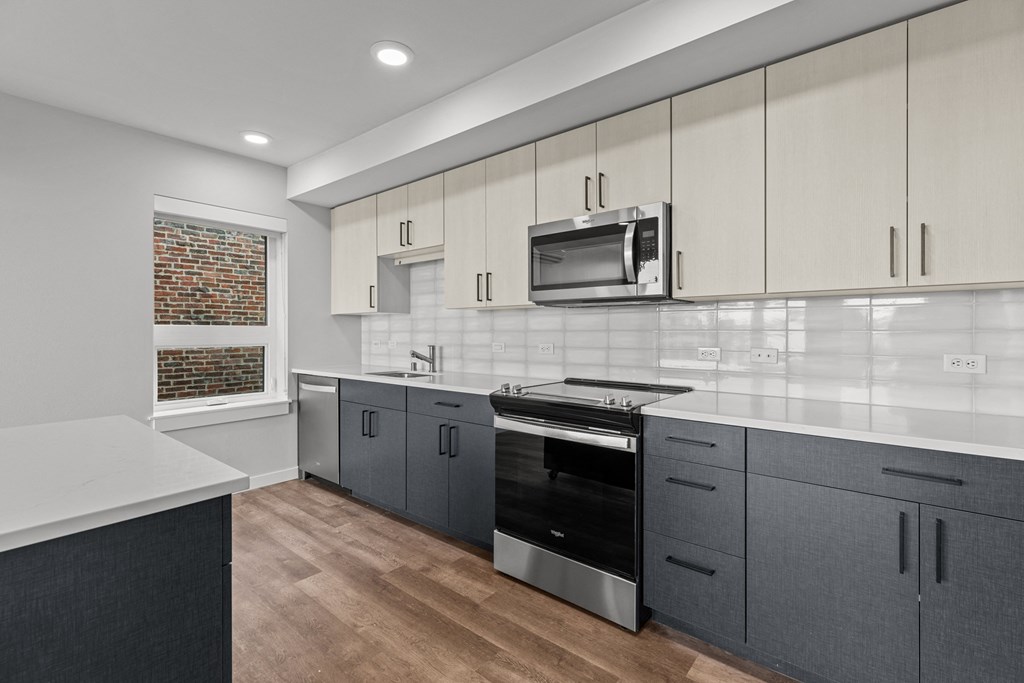 a modern kitchen with white cabinets and stainless steel appliances